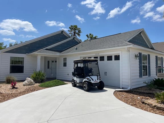 Sunlit open-concept retreat w/granite kitchen island, golf cart & dual lanai.